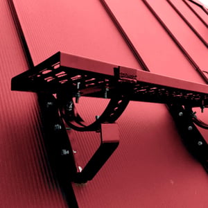 Looprooster set van purperrood (RAL 3004) verzinkt staal gemonteerd op een dak met profielplaten