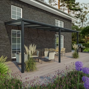 Terrasoverkapping in RAL 7016 voor een huis met donker metselwerk, op een houten terras
