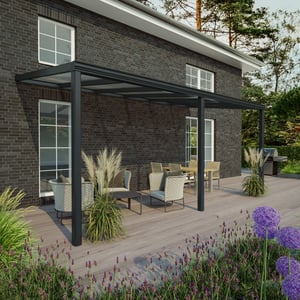 Terrasoverkapping RAL 7016, 16 mm, gemonteerd aan een huis, met tuinmeubelen op een houten terras