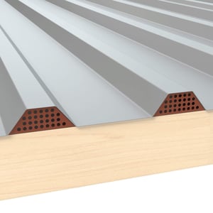 Geperforeerd tandprofiel in koperbruin (RAL 8004) onder grijze damwandplaat op houten constructie