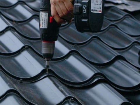 Professionele bevestiging van een dakpanplaat met een accuschroevendraaier, een voorbeeld voor een correcte montagetoepassing