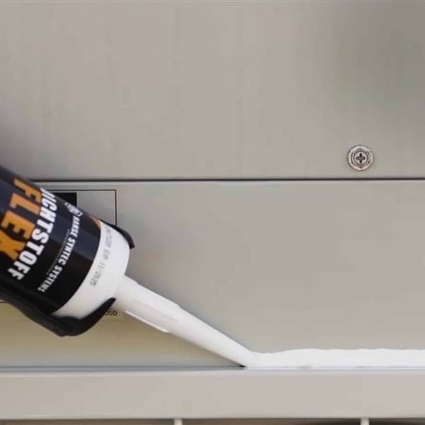 Afdichtingskit FLEX in witte kleur wordt met kitpistool op metalen voeg aangebracht