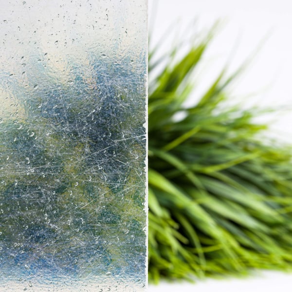 Detail van de heldere polyester lichtplaat 1,30 mm met waterdruppels en wazige achtergrond