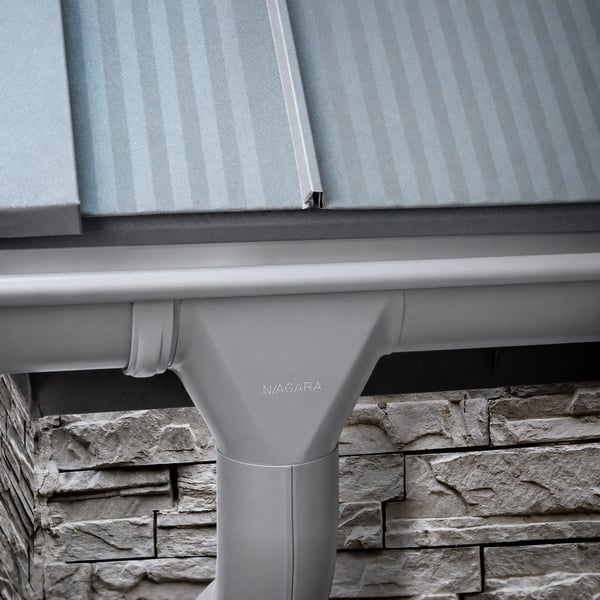 Niagara dakgoot in grijs aluminiumkleurig (RAL9007) gemonteerd onder een dak met profielplaten