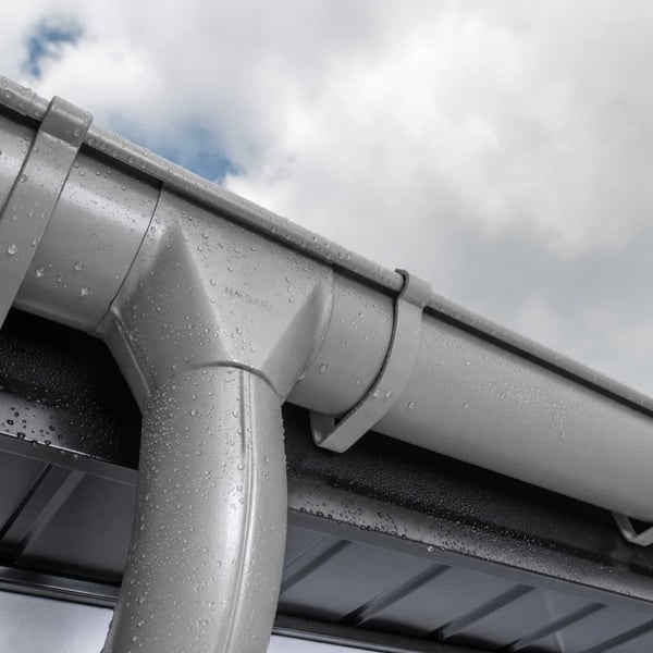 Detail van een grijs aluminiumkleurige (RAL9007) Niagara dakgoot met waterdruppels op de coating