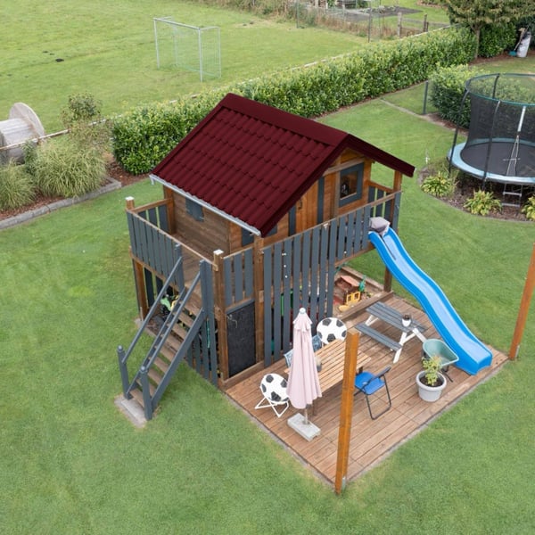 Dakpanplaat Wijnrood (RAL 3005) op het dak van een speelhuis, installatie in de tuin