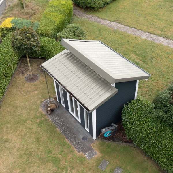 Dakpanplaat Grijswit op het dak van een modern tuinhuis met lessenaarsdak