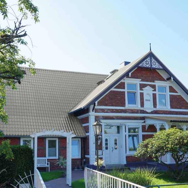 Dakpanplaat 2/1060 aluminium RAL9007 op een historisch woonhuis met rode bakstenen gevel