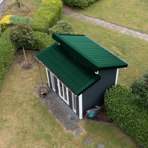 Tuinhuis met twee mosgroene dakpanplaat-dakvlakken onder verschillende hoeken