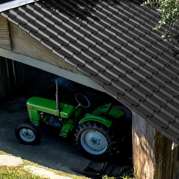 Dakpanplaat EUROPA Gitzwart op een carport, met daaronder een groene tractor