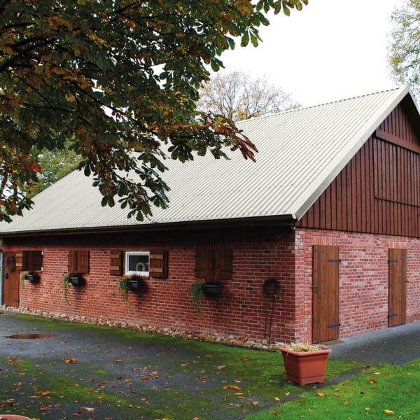 Damwandplaat 20/1100, Grijswit (RAL 9002), gemonteerd op een bakstenen gebouw, zijaanzicht