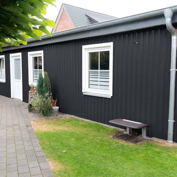 Aanbouw met wandbekleding van damwandplaat 20/1100 aluminium 0,70 mm antracietgrijs en witte ramen