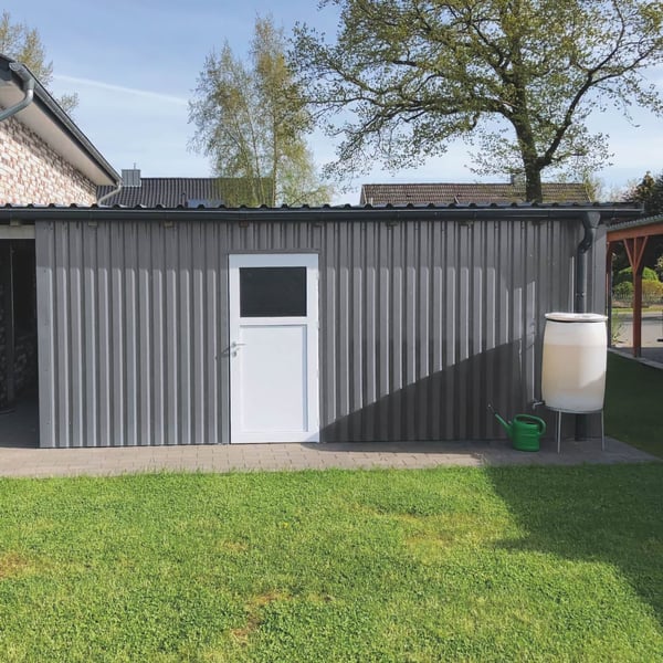 Damwandplaat 20/1100 aluminium 0,70 mm, RAL9007, als gevelbekleding van een garage met witte deur