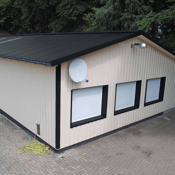 Damwandplaat 35/207 antracietgrijs als dak op een licht gebouw met zwarte kozijnen