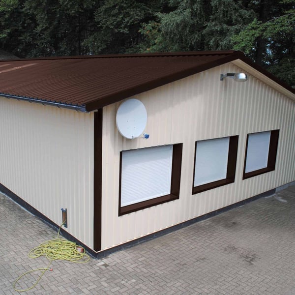 Damwandplaat 35/207 in chocoladebruin als dak op een gebouw met lichte wanden
