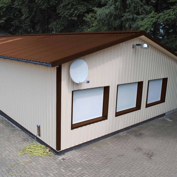 Damwandplaat 35/207 Notenbruin als dak op een gebouw met lichte gevelplaten