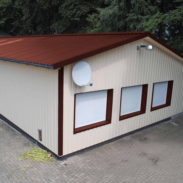 Damwandplaat 35/207, Roodbruin (RAL 8012) op een opslaggebouw met lichte wanden