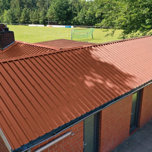Damwandplaat 35/207 in koperbruin op een gebouw met schoorsteen als dakbedekking