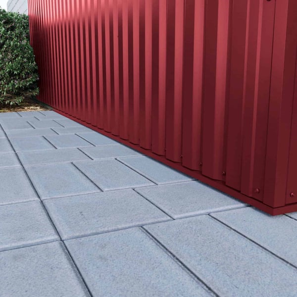 Detailaanzicht van de onderrand van damwandplaat 35/207 wand Wijnrood (RAL 3005) op een muur