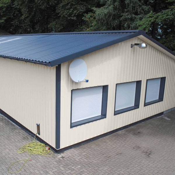 Damwandplaat 35/207 wand in Grijswit (RAL 9002) op de gevel van een klein gebouw