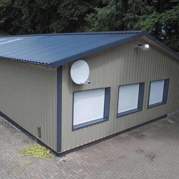 Klein gebouw met wandbekleding van grijs aluminiumkleurige damwandplaat 35/207