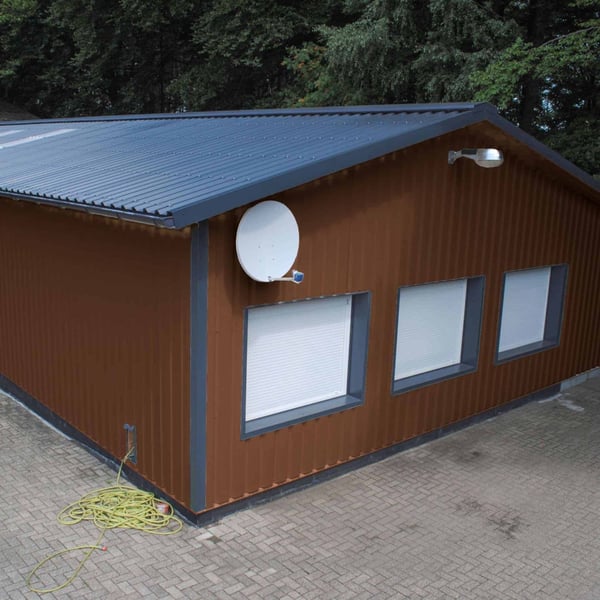 Hal met wandbekleding van damwandplaat 35/207 Notenbruin (RAL 8011) en donker dak
