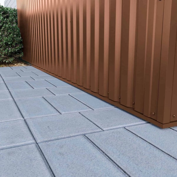 Detailaanzicht van de onderrand van damwandplaat 35/207 Notenbruin (RAL 8011) aan een wand