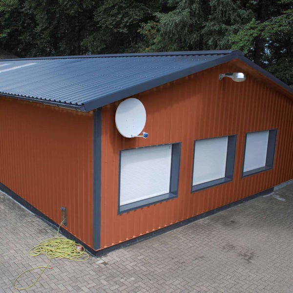 Hal met wandbekleding van damwandplaat 35/207 in koperbruin en donker dak