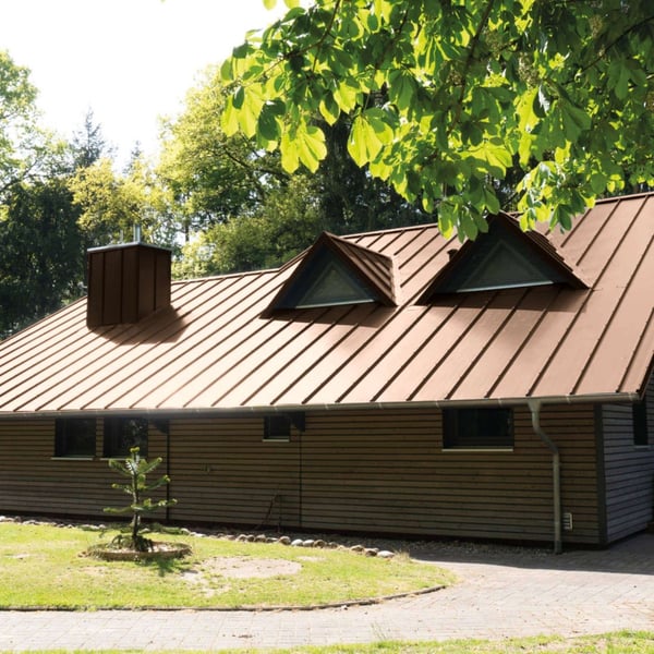 Staande felsplaat 33/500-LE Sepiabruin op een dak van een huis met dakkapellen en schoorsteen