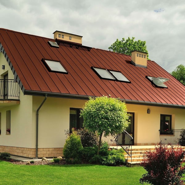 Staande felsplaat PD-510-S trapezium Terracotta op een dak met meerdere dakramen en dakkapellen