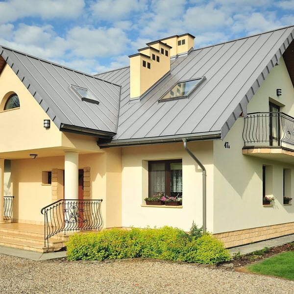 Huis met dak van lichtgrijze felsplaat PD-510-S trapezium en dakramen