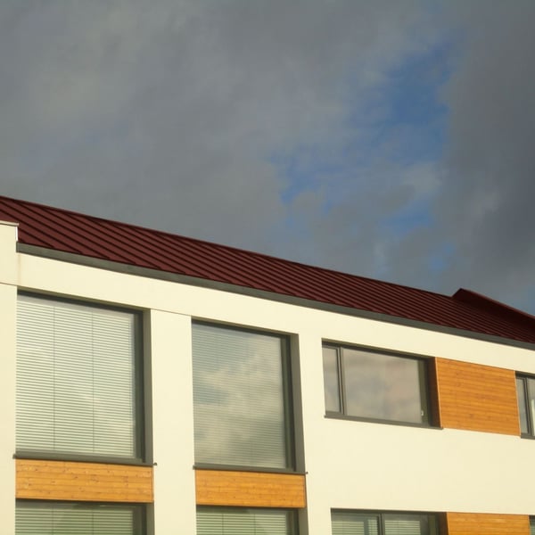 Staande felsplaat PD-510-S damwandplaat roodbruin op een modern gebouw