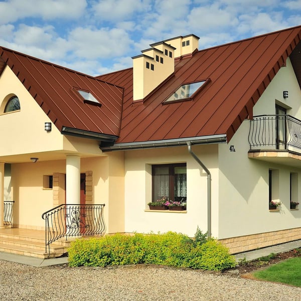 Staande felsplaat PD-510-S trapezium terracotta op een dak met dakkapellen en schoorstenen