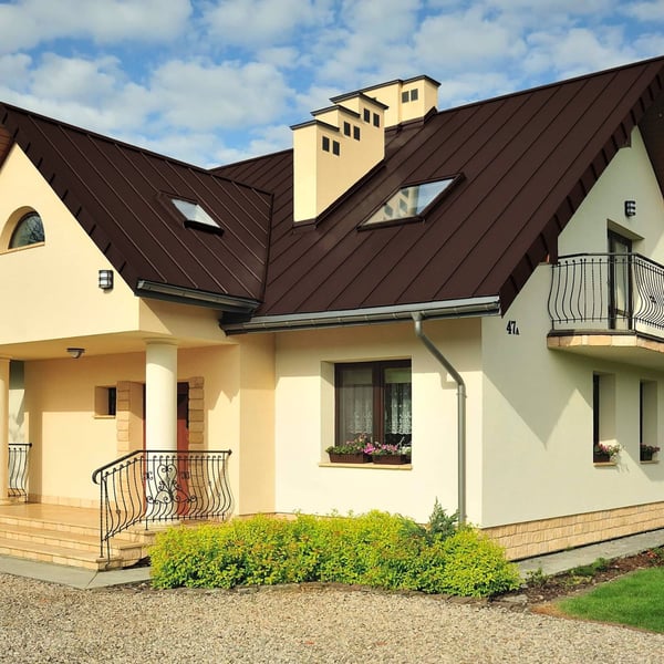 Staande felsplaat PD-510-S trapezium Chocoladebruin op een woonhuis met dakkapellen en dakramen