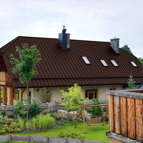 Staande felsplaat PD-510-S trapezium Chocoladebruin op een woonhuis met tuin en schommel