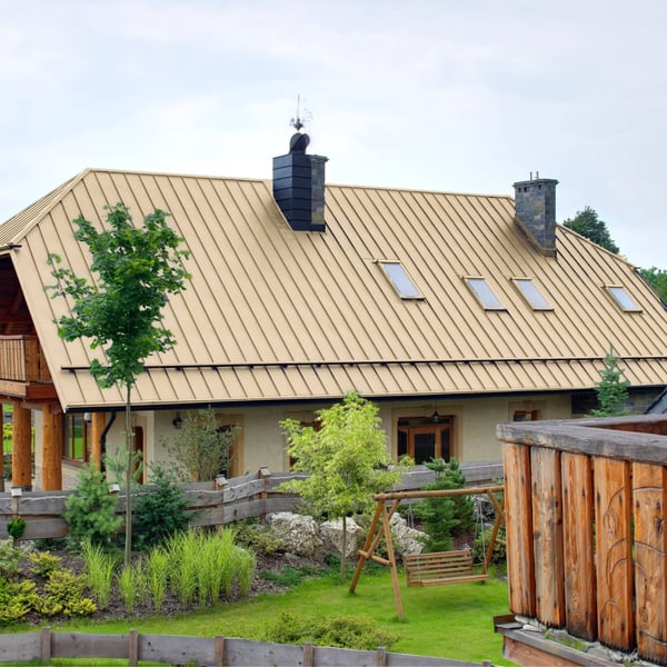 Groot huis met staande felsplaat PD-510-S trapezium in licht ivoor (RAL 1015) op het dak