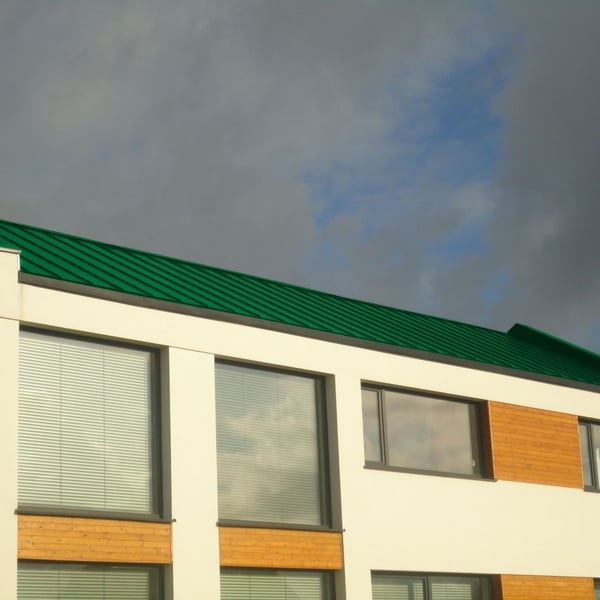 Modern gebouw met mintgroen staande felsplaat PD-510-S dak en grote ramen