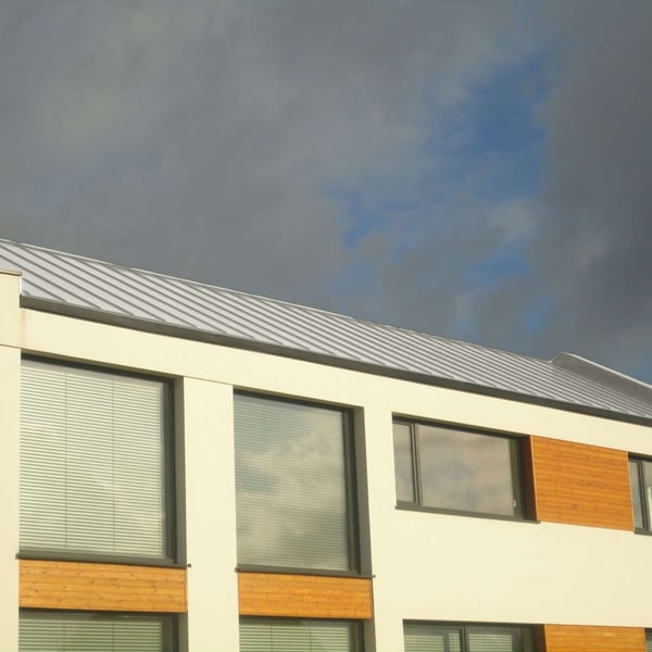 Staande felsplaat PD-510-S damwandplaat Grijswit op een modern gebouw onder donkere lucht