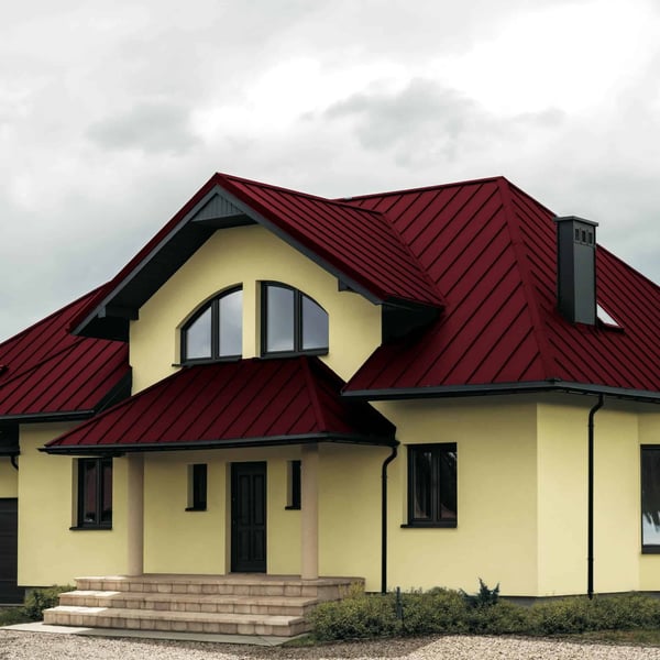 Huis met complex dak van felsdakpan PD-510-S Micro in Wijnrood (RAL 3005)