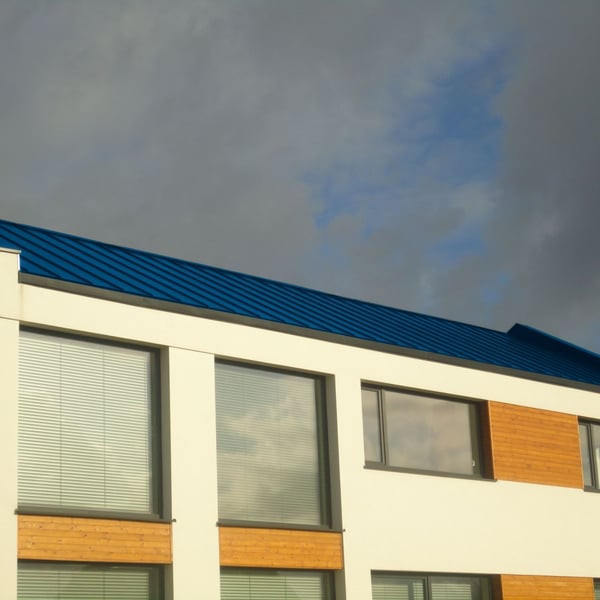 Felsplaat PD-510-S Micro Gentiaanblauw (RAL 5010) op een plat dak van een modern gebouw