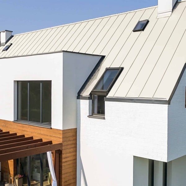 Staande felsplaat PD-510-S Zuiverwit (RAL 9010) op een moderne aanbouw met dakramen, verlegd