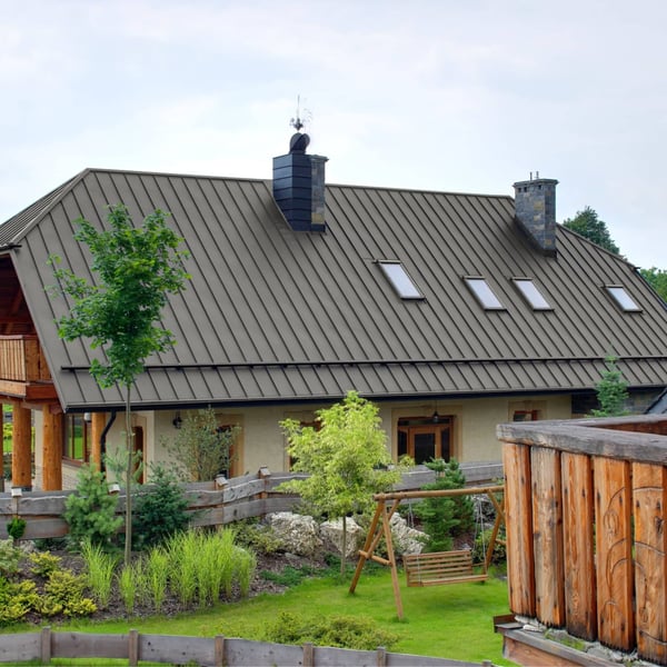 Staande felsplaat PD-510-S in grijs aluminium (RAL9007) op een woonhuis met tuin en schommel