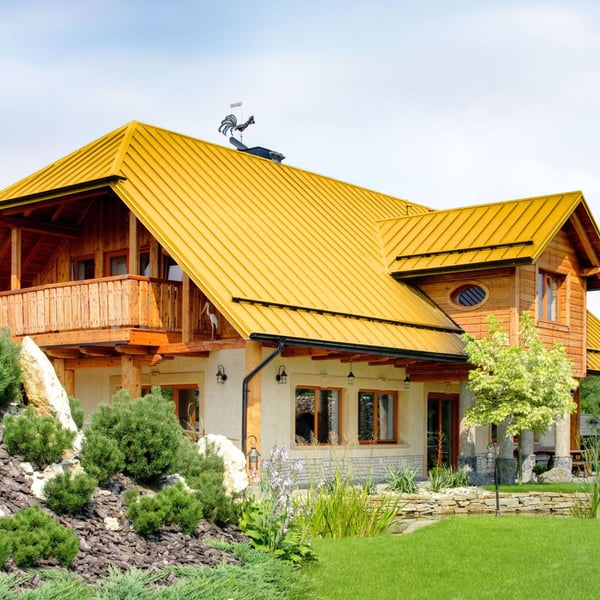 Huis met dak van felsplaat PD-510-S in Koolzaadgeel, met dakkapel en balkon