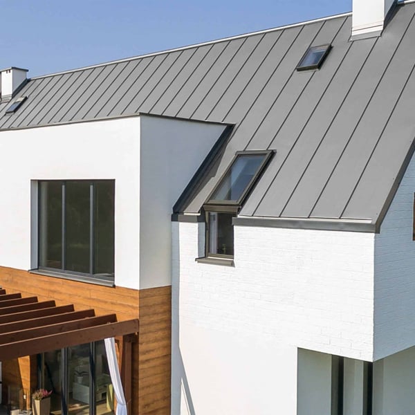 Felsplaat PD-510-S Zilver-Metallic op een wit huis met dakramen en houten elementen