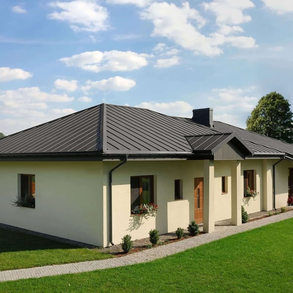 Felsplaat PD-510-S Nano, grijs aluminiumkleurig, op een bungalowdak met schoorsteen