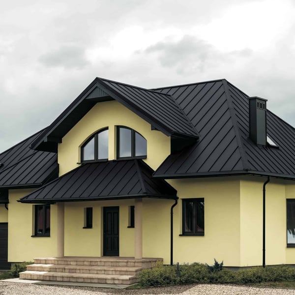 Huis met dak van staande felsplaat PD-510-S Vlak in Grafietgrijs, met gevel en zuilen