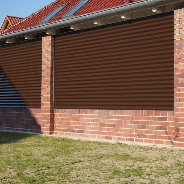 Golfplaat 18/1064 Notenbruin RAL 8011 als gevelbekleding op een huis met bakstenen gevel