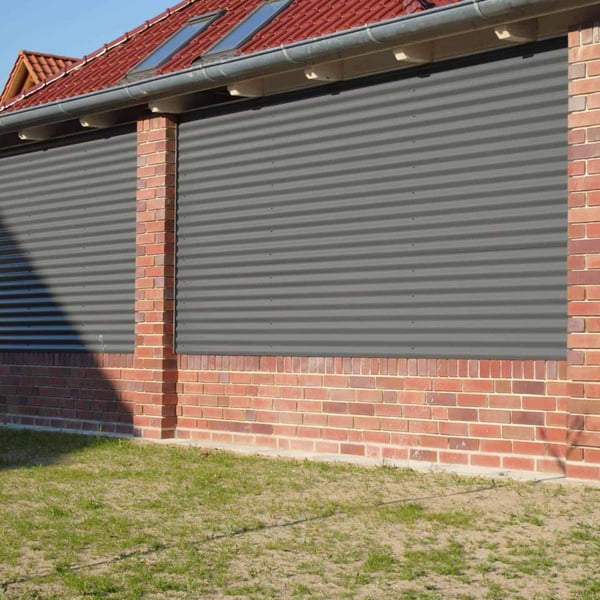 Golfplaat 18/1064 aluminium 0,70 mm, RAL9007, als wandbekleding op een bakstenen huis