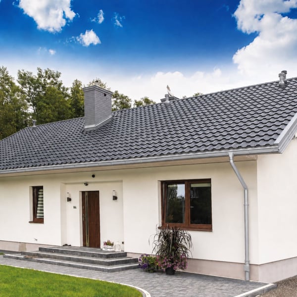 Huis met gemonteerde dakgoten en rinnenablauf van titaanzink