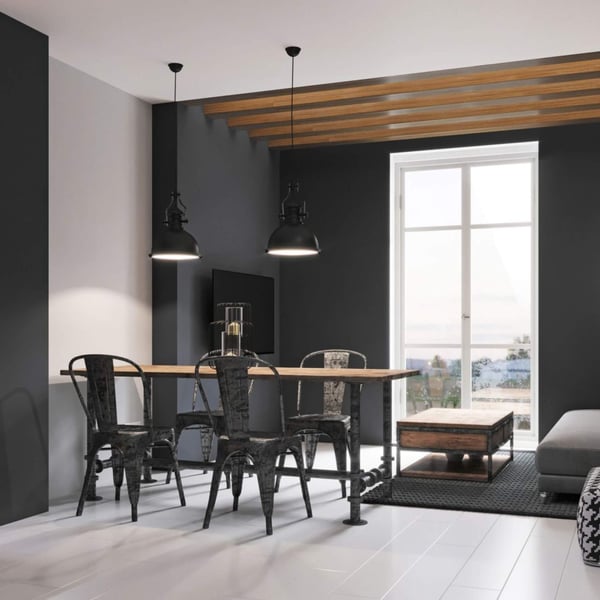 Eethoek met donkere muren, houten tafel, zwarte metalen stoelen en plafondbalken